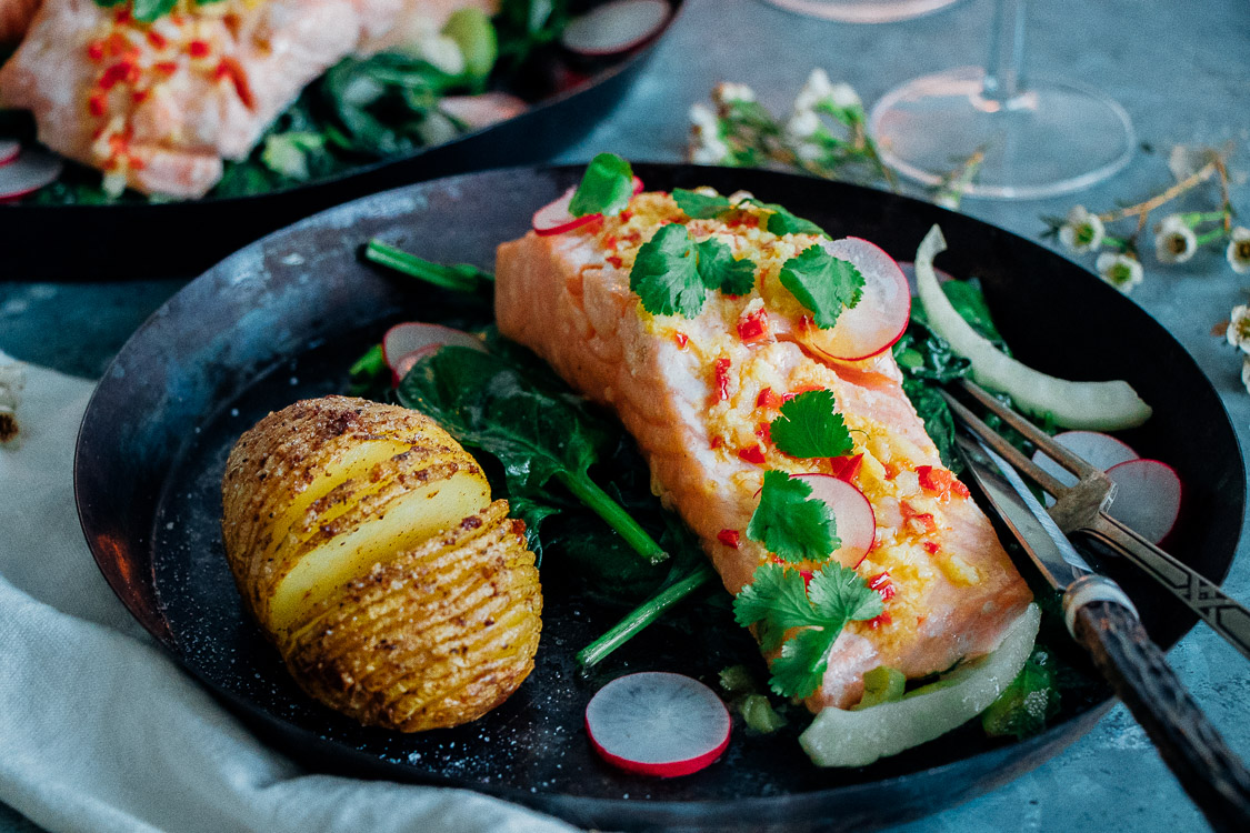 Zalm uit de oven met een dressing van limoen, rode peper en gember op een bedje van spinazie, prei en venkel