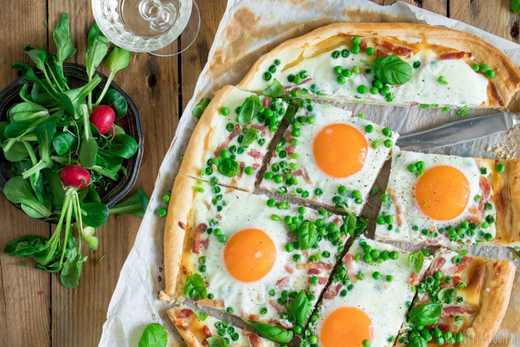 Lente flammkuchen met crème fraiche, erwtjes, spekjes, eitjes en basilicum