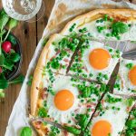 Lente flammkuchen met crème fraiche, erwtjes, spekjes, eitjes en basilicum