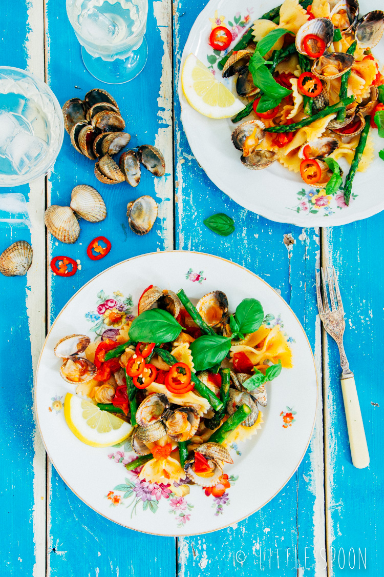 Lauwwarme pittige pastasalade met kokkels, groene asperges, tomaten en rode peper