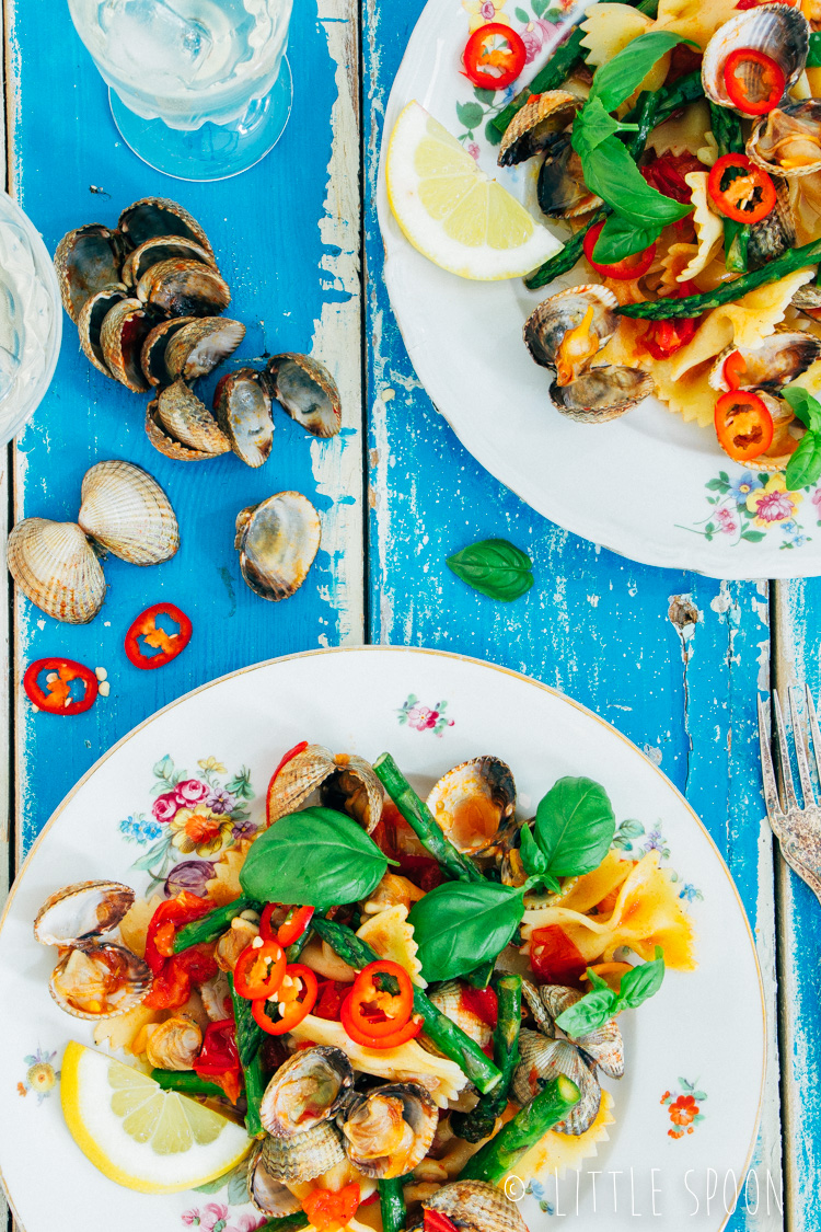 Lauwwarme pittige pastasalade met kokkels, groene asperges, tomaten en rode peper