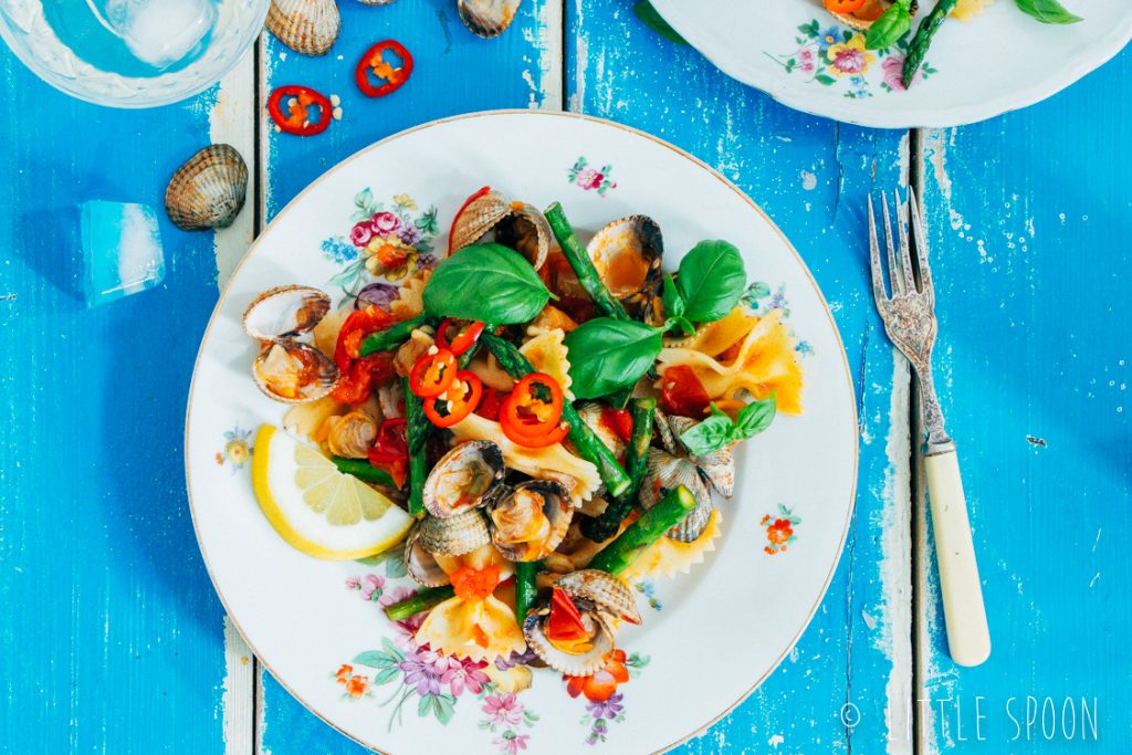 Lauwwarme pittige pastasalade met kokkels, groene asperges, tomaten en rode peper